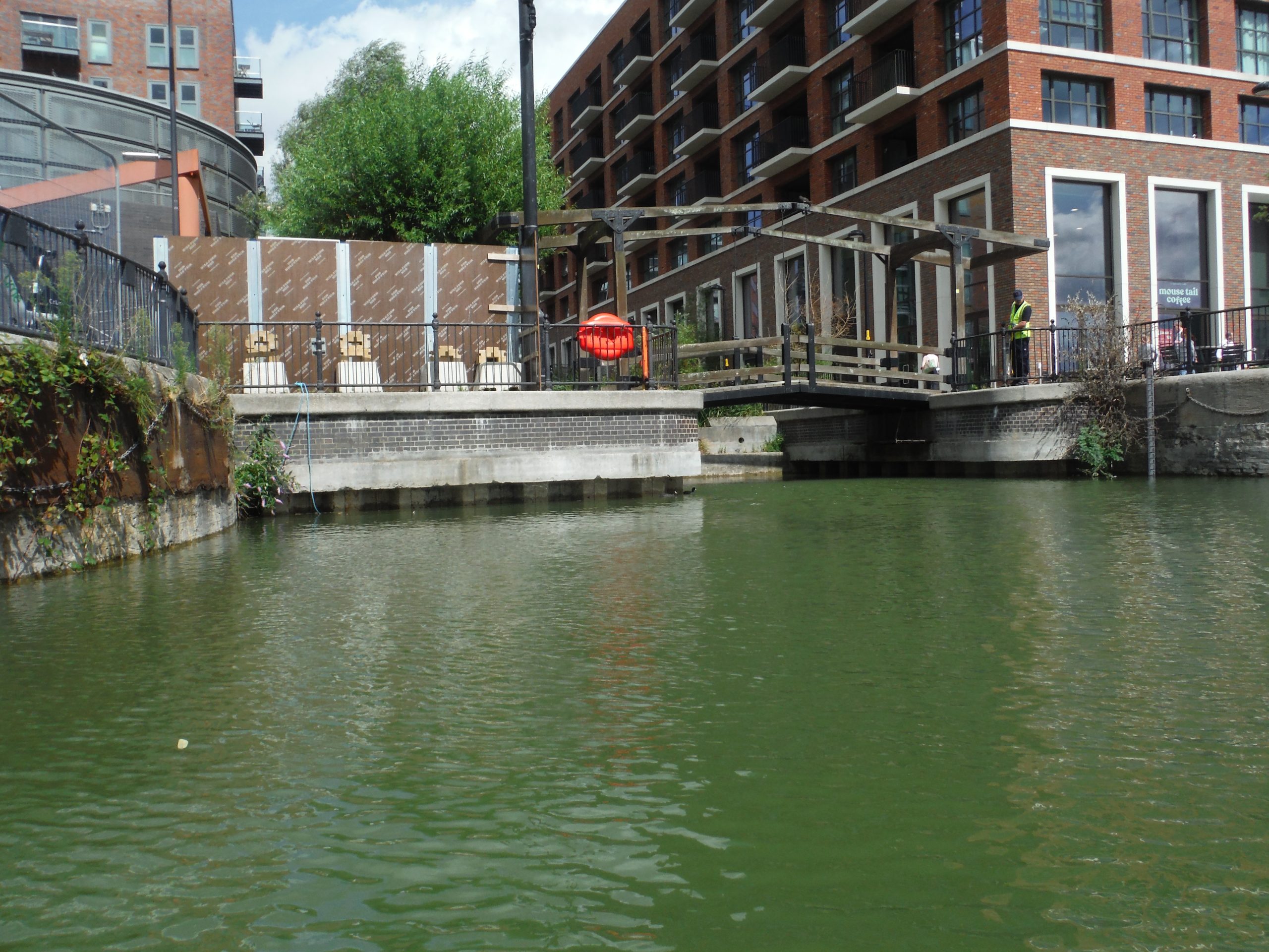 View of Albion Bridge structure spanning Dockside Canada Water, showing calm water and surrounding urban landscape